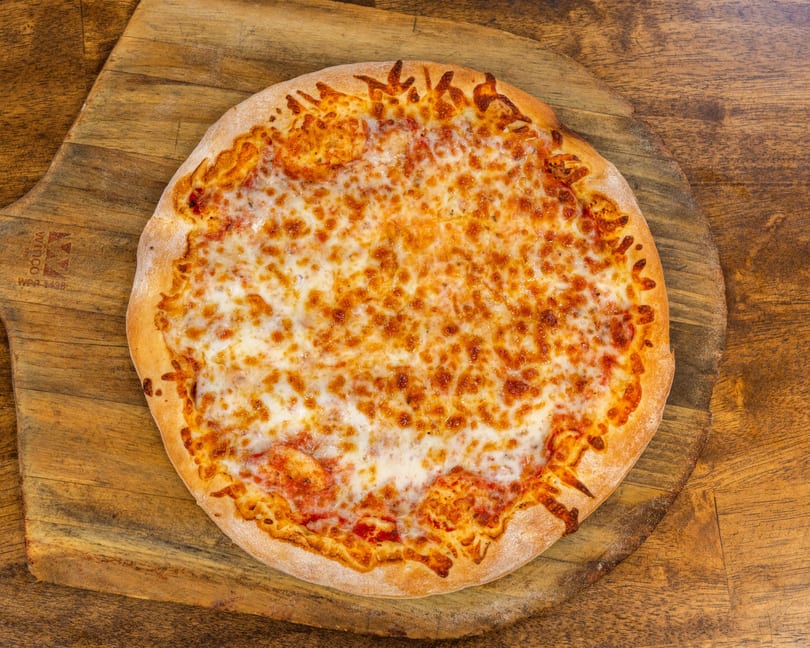 A whole cheese pizza with melted mozzarella and a golden crust, on a wooden pizza peel.
